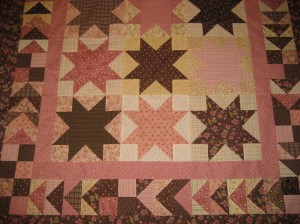 Pink and brown Sawtooth Stars made with fabrics from Henry Glass