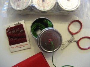 THE STRING THING, along with teeny-tiny airplane approved scissors, and a package of the best embroidery needles EVER!